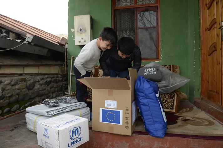 Eltaj and Eljad are looking at the items delivered by UNHCR