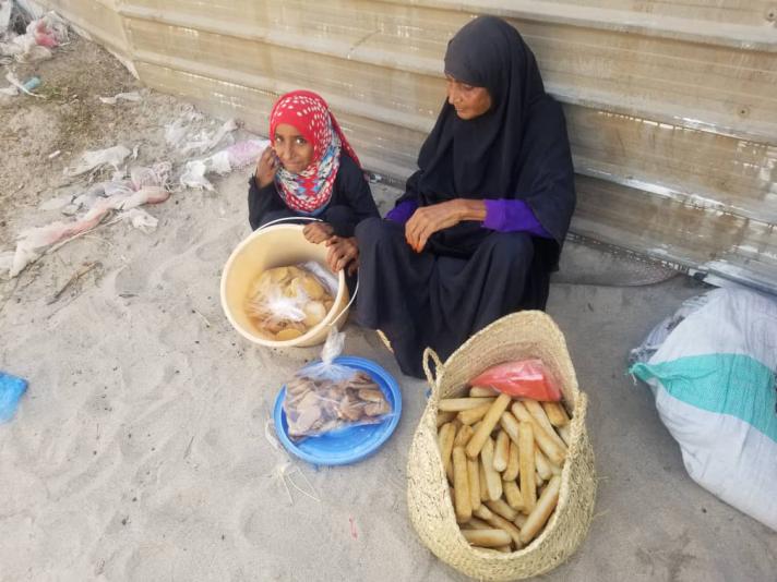 Aisha and her granddaughter showing baskets with food