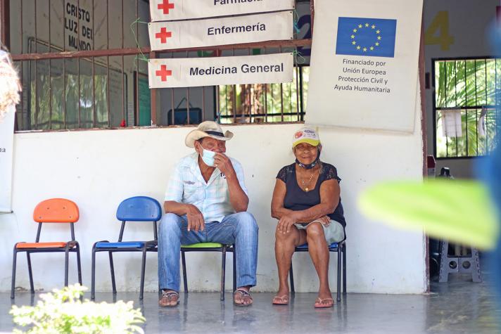 2 people sitting on a chair outside a medical unit