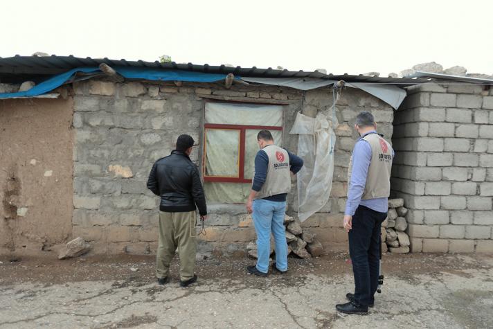 Aid workers and resident checking onto a shelter