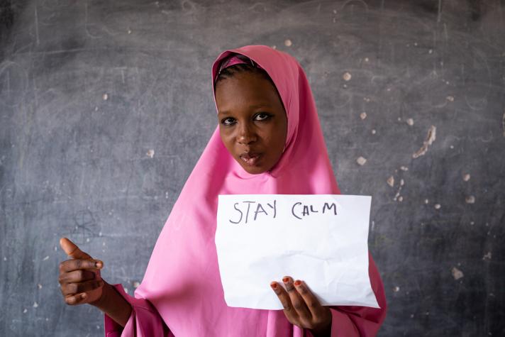 Girl holding up the text 'Stay calm'