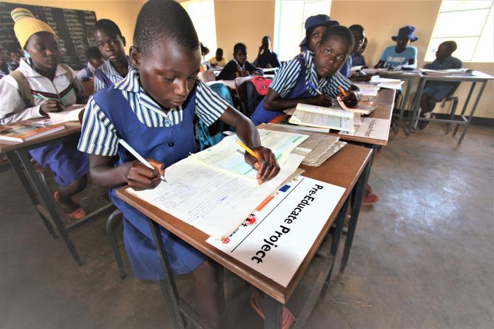 Students writing while sitting at schooldesks