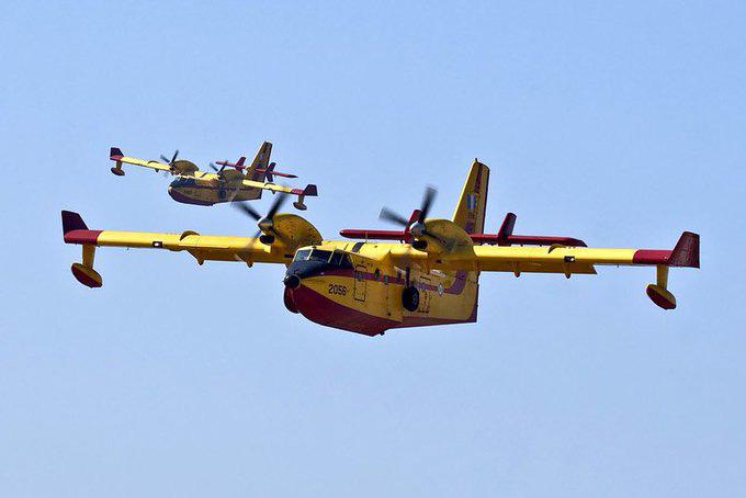 2 firefighting planes flying next to each other 