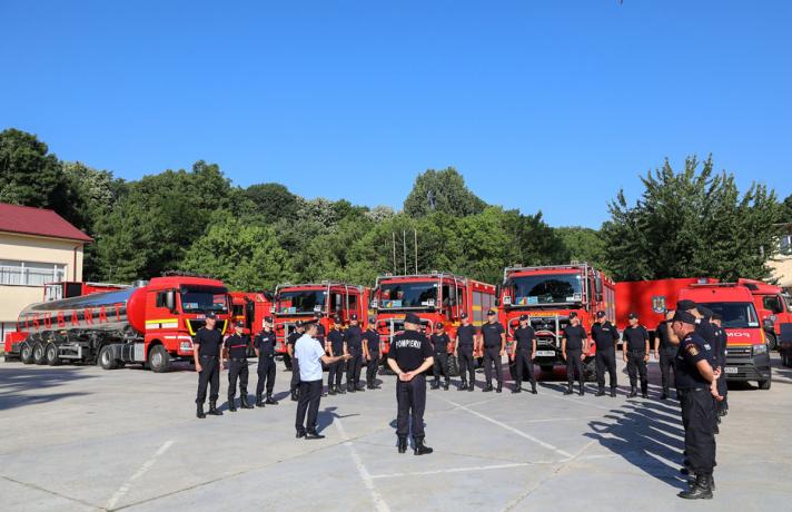 A team of firefighters in front of firefighting trucks