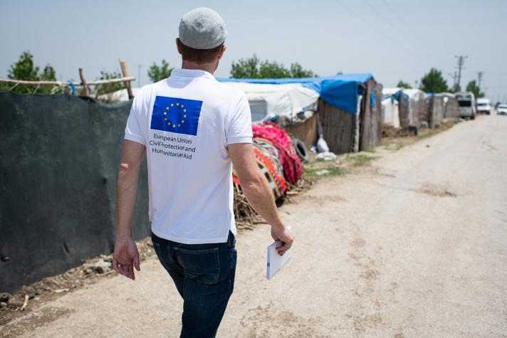 Aid worker walking on a road in the refugee settlement