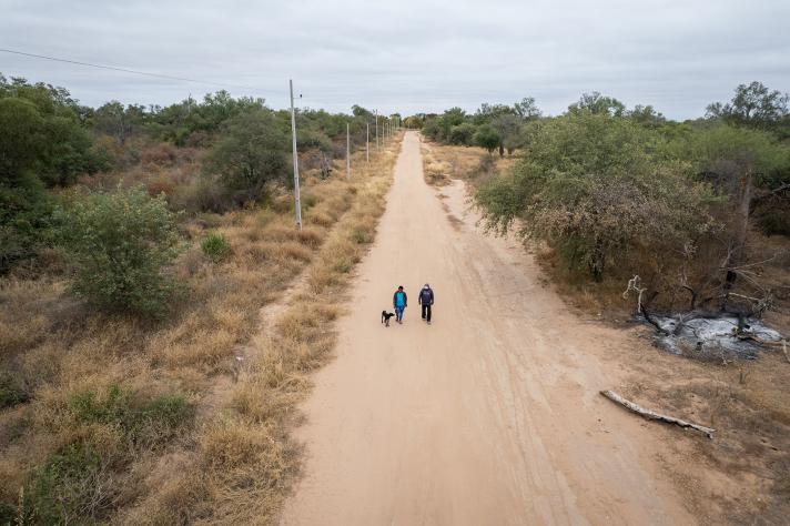 Aerial view of a sand road with 2 children in a distance