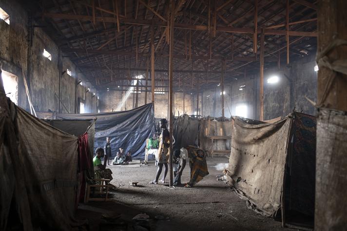 children and women sheltering in an abandoned warehouse