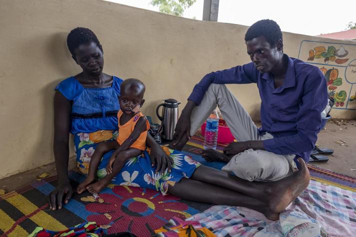 Outside in the hospital courtyard sits Dhieu Deng, 28, himself a nurse, and the father of Ajang Dhieu, just 18 months old.