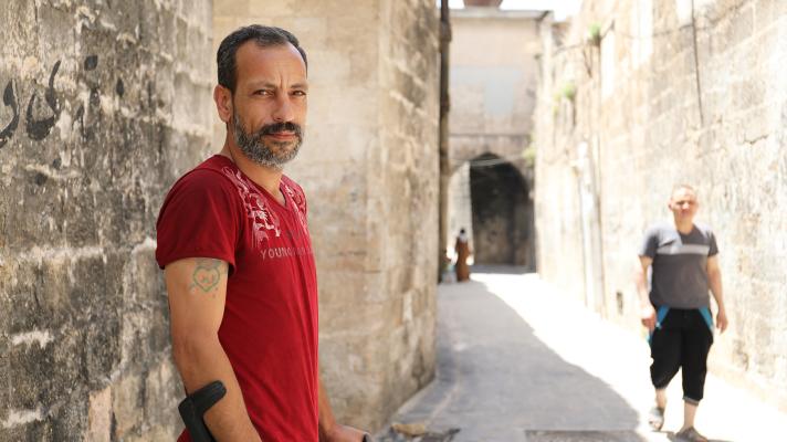 photo of Maher standing in a narrow empty street