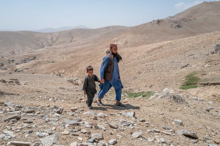 Father and son walking in a desolated landscape.