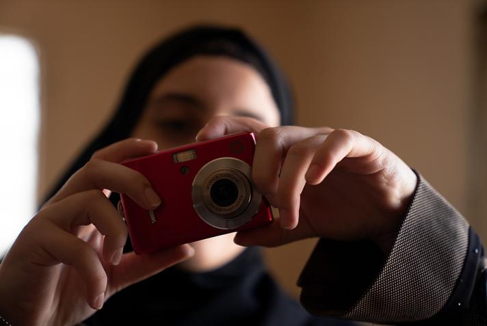 Aya capturing a photo while holding the camera in front of her face.