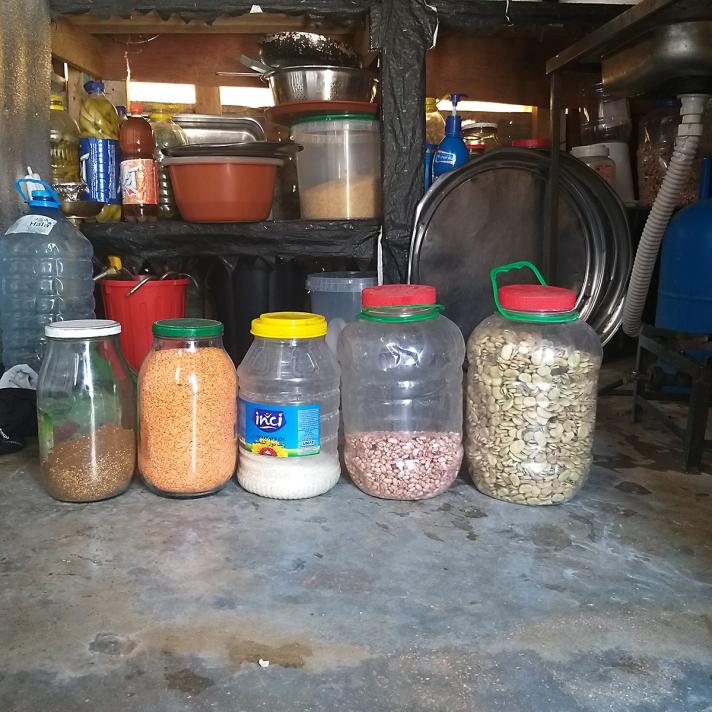 View of a kitchen table with jars holding rice, bulgur, and beans.