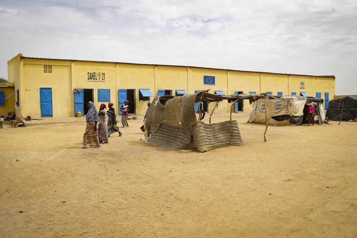 View of a schoolbuilding, in front some makeshift tents.