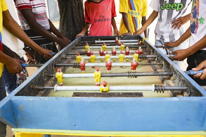 Close up of a football table with hands playing the game.