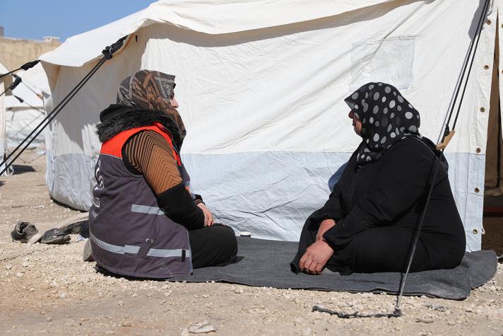 2 women in front of a shelter tent