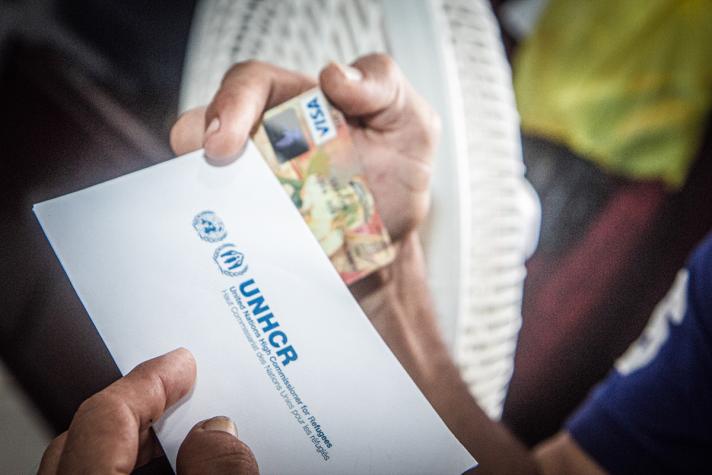 A hand holding an enveloppe and payment card.