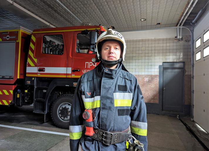 Andriy, a Ukranian firefighter, standing in front of a firefighting truck