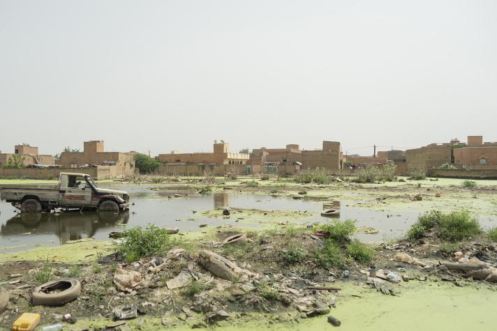 View of the outskirts of a city, a truck in flooded land.
