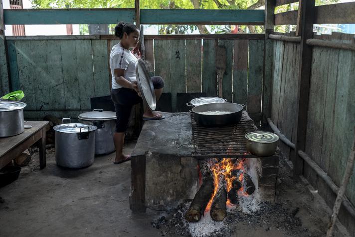 View of an outdoor kitchen while a woman is preparing food.