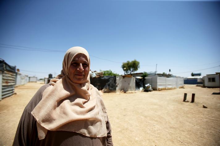 Photo of Fadwa, in the bacground part of the camp she lives in.