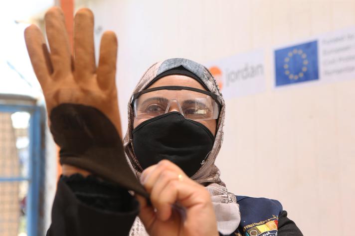 Seham wearing work gloves and protective glasses.