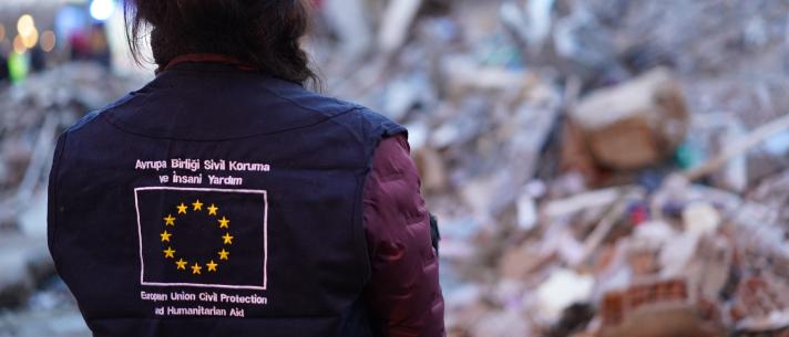 Person seen from the back, on the jacket is the EU flag with text.