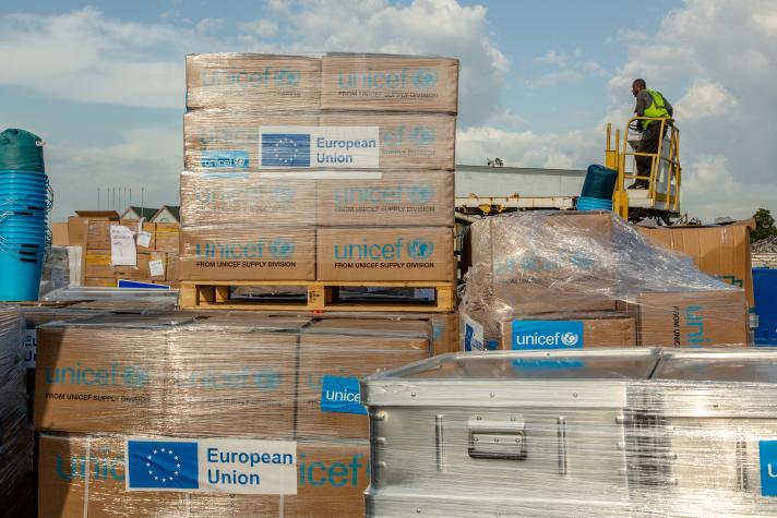 Boxes of essential supplies, a european flag with text on them.