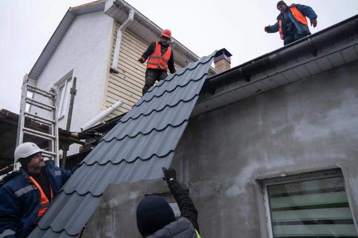 3 builders mounting a rooftop plate.