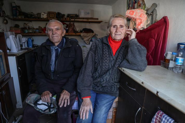 Photo of Kateryna sitting next to her husband in the kitchen.