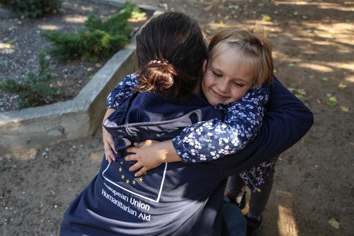 An aid worker being hugged by one of Iryna's children.