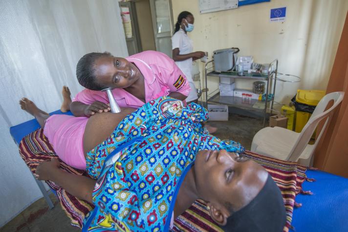 A midwife examines a pregnant woman in an EU-supported health facility in Nakivale (left).