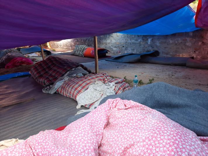 View of sleeping mats under neath a makeshift tent.