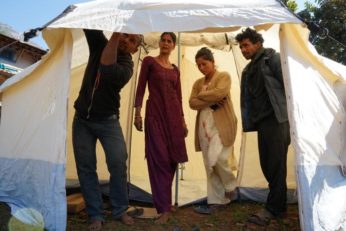 Group of people standing in the entrance of a tent.