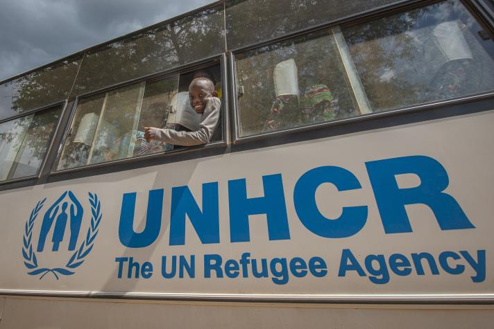 Close up of the side of a bus with the UNHCR logo on it.