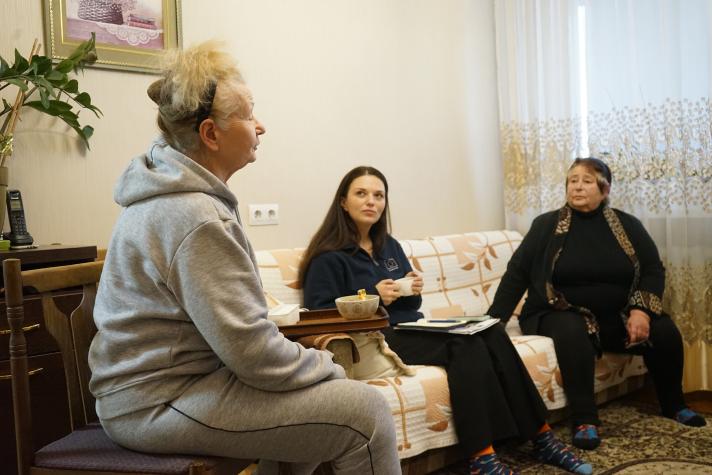 Ivanna - an aid worker - sitting on a sofa together with Elena and Svitlana.