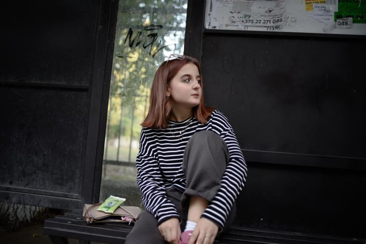 Photo of Alvina sitting on a bench.