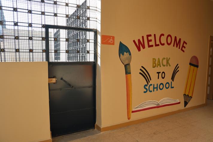 View of a wall with a painting of a pencil and a paintbrush with the text 'Welcome back to school'.