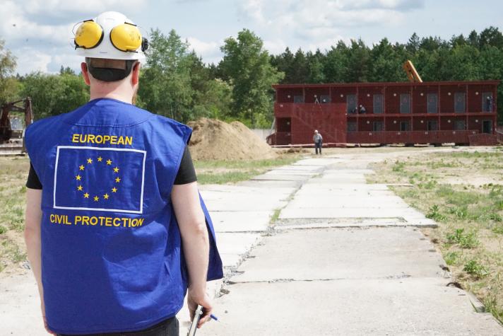 An aid worker standing outside in an empty lot