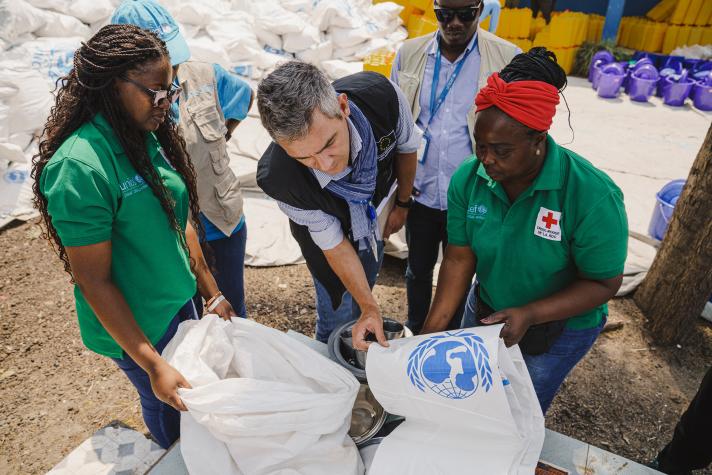 Norik rogether with 2 aid workers preparing a kit with supplies.