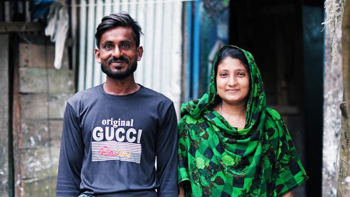 Billal Howlader and his wife Sajia Akhter in front of their house.