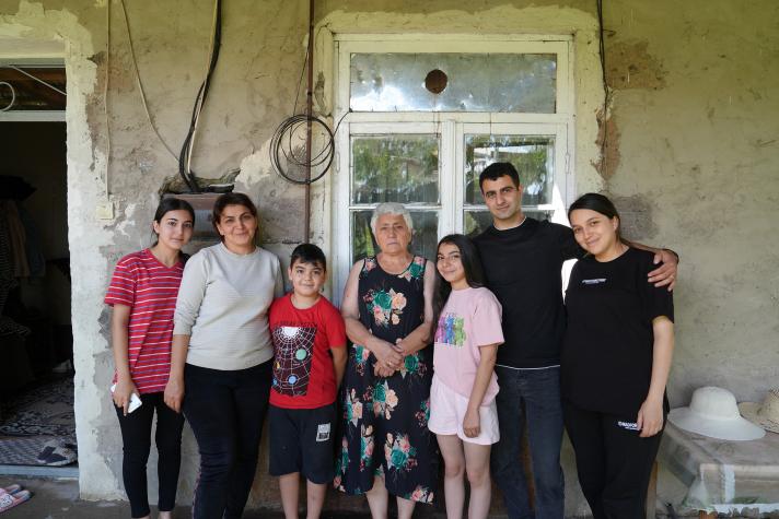 Evelina (from left, the second) with her family in front of their house.