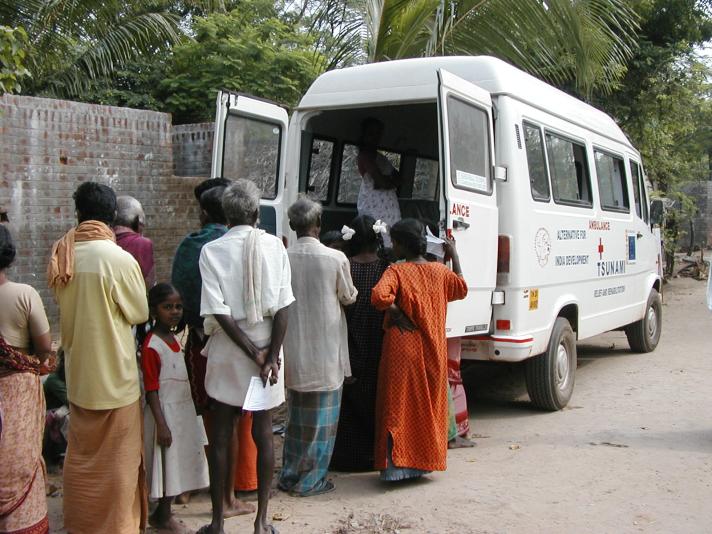 people lining up to receive aid from a truck