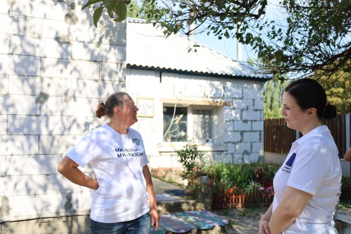 Kateryna and Ivanna talking in front of the renovated house.