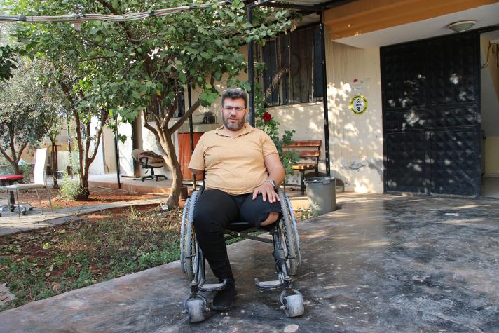 Mohammad in his wheelchair in front of his house.