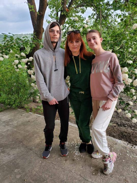 Svetlana and her 2 children in front of a tree