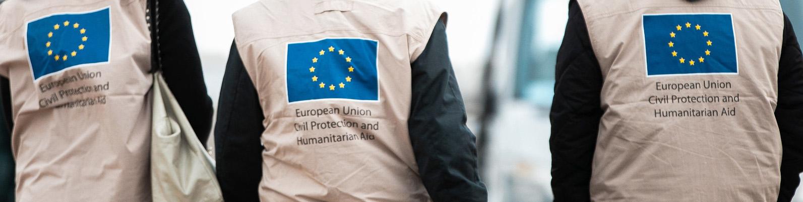 3 EU flags on the backside of humanitarian aid workers