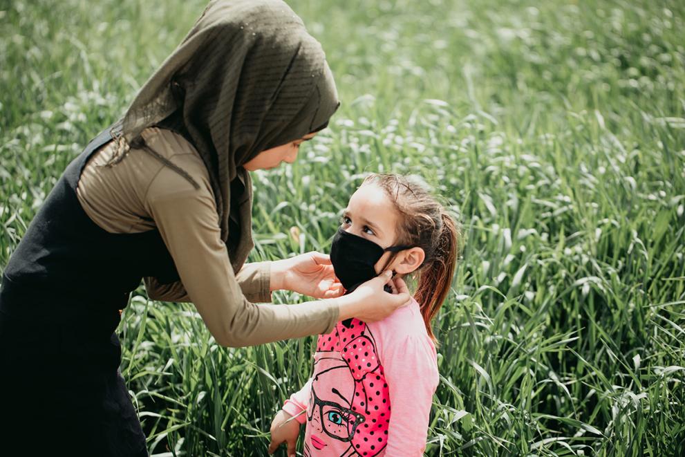Rabouaa putting a mask onto a child