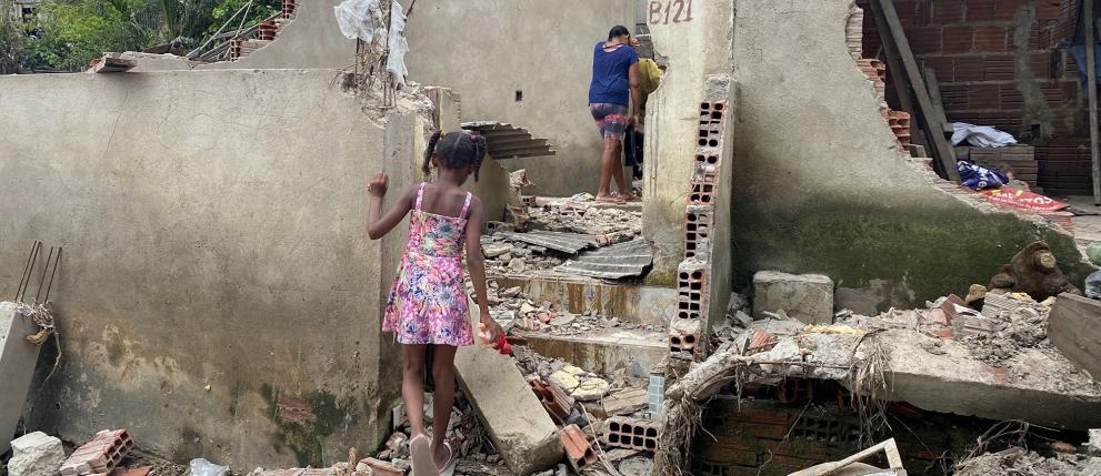 People looking into the debris of their destroyed house