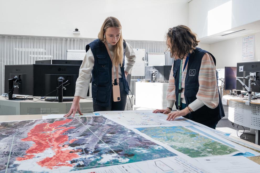 2 civil protection colleagues looking at a map on a table