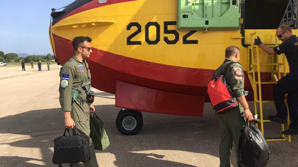 People boarding a forest fire plane carrying bags